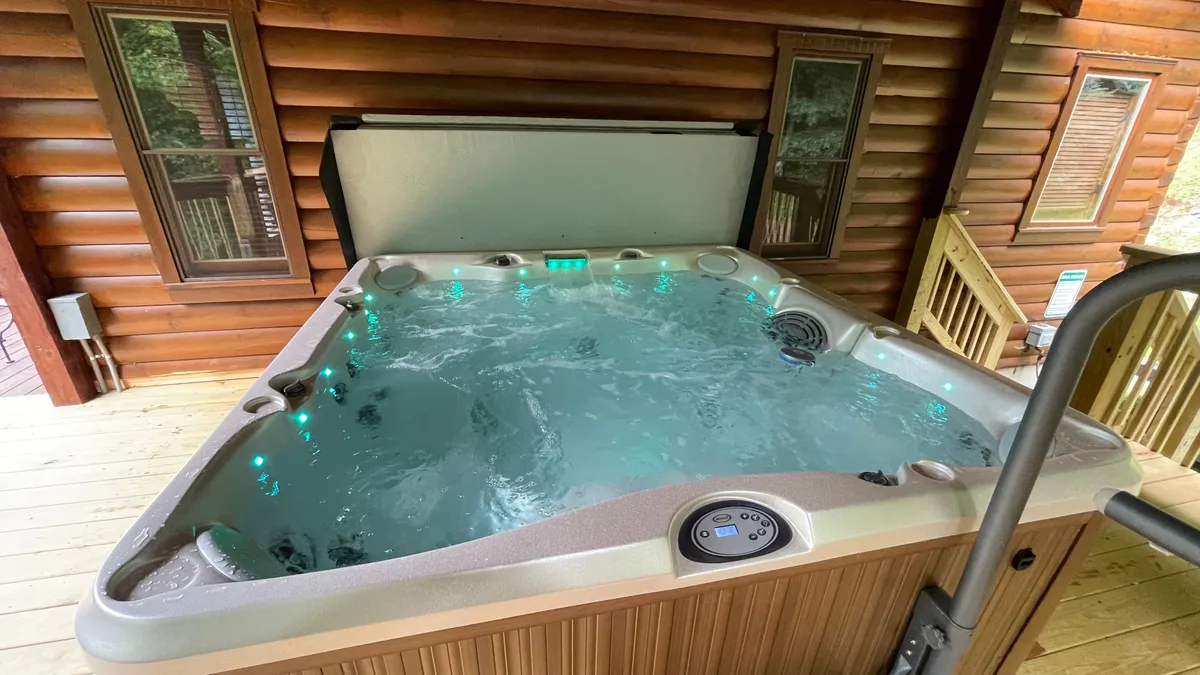 An inviting hot tub surrounded by wooden structure and subtle lighting, offering a tranquil space to soak and relax after an active day outdoors.